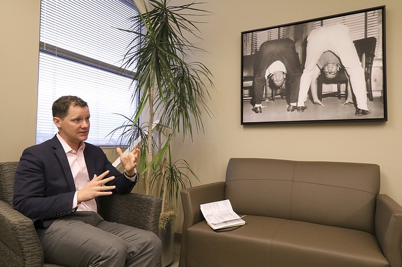 David Caines, Chief Operating Officer at Kenco Logistic Services, speaks about his job and company during a meeting at his Chattanooga office on Monday, February 9, 2015. Caines keeps a lighthearted image of the company founders Sam Smartt and Jim Kennedy Jr. on his wall to motivate employees to be open with him.