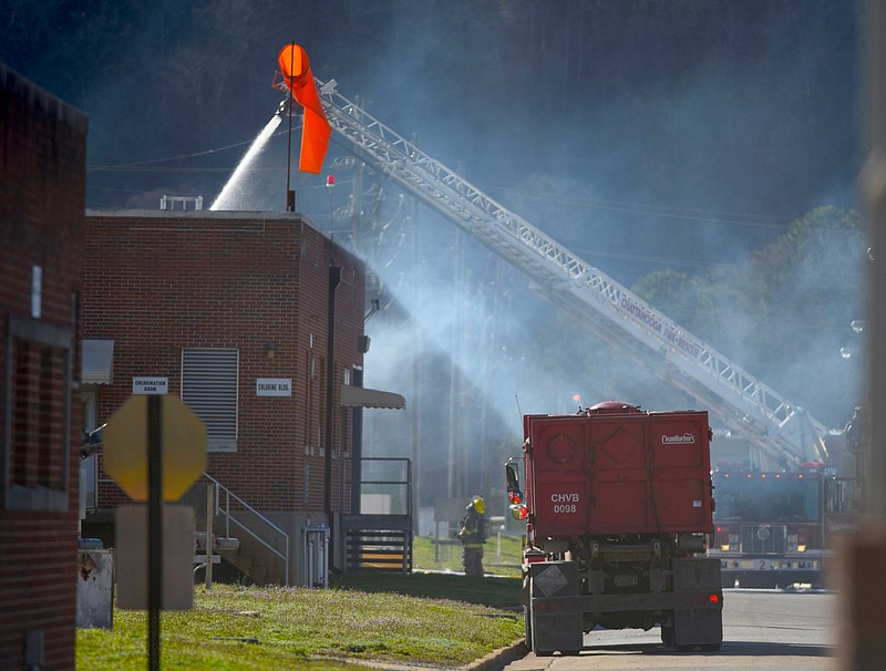 Chattanooga Fire Department responders use a remote ladder pumper to hose down the chlorine building as smoke pours from the top at the Moccasing Bend Wastewater Treatment facility Monday, Mar. 16, 2015, in Chattanooga.