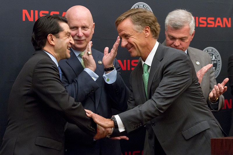 Tennessee Gov. Bill Haslam, right, shakes hands with Jose Munoz, the chairman of Nissan North America, after announcing that the Japanese automaker plans to build a $160 million supplier park in Tennessee at the state Capitol in Nashville on Tuesday, March 17, 2015. At rear are state Sens. Bill Ketron, R-Murfreesboro, and Jim Tracy, R-Shelbyville. 