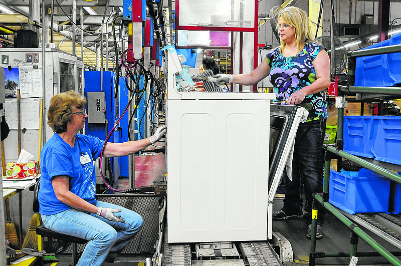 Roper Corporation employee's Faye Goins, left, and Stacy Johnson run ground path testing on a new appliance on the production line in LaFayette. The appliance manufacturer  has taken aggressive steps to promote wellness by creating an onsite medical and wellness center for their employees and families.