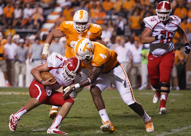 University of Tennessee Volunteers defensive lineman LaTroy Lewis (4) tackles Austin Peay State University Governors quarterback Jacob Sexton (7) during the second half at Neyland Stadium in Knoxville, Tenn., on Saturday, Aug. 31, 2013.