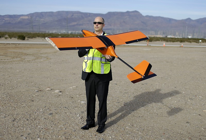 
              FILE - In this Dec. 19, 2014, file photo, Dan Johnson of Sensurion Aerospace holds the Sensurion Aerospace Magpie commercial drone during an event near Boulder City, Nev. Federal aviation officials say they are streamlining their rules to expedite permits to fly commercial drones as long as flights remain under 200 feet in altitude. (AP Photo/John Locher, File)
            