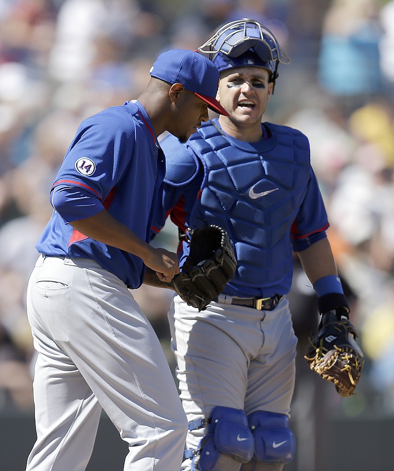 
              Chicago Cubs' Edwin Jackson, left, speaks with catcher Miguel Montero in the third inning of a spring training exhibition baseball game against the Oakland Athletics Tuesday, March 24, 2015, in Mesa, Ariz. (AP Photo/Ben Margot)
            
