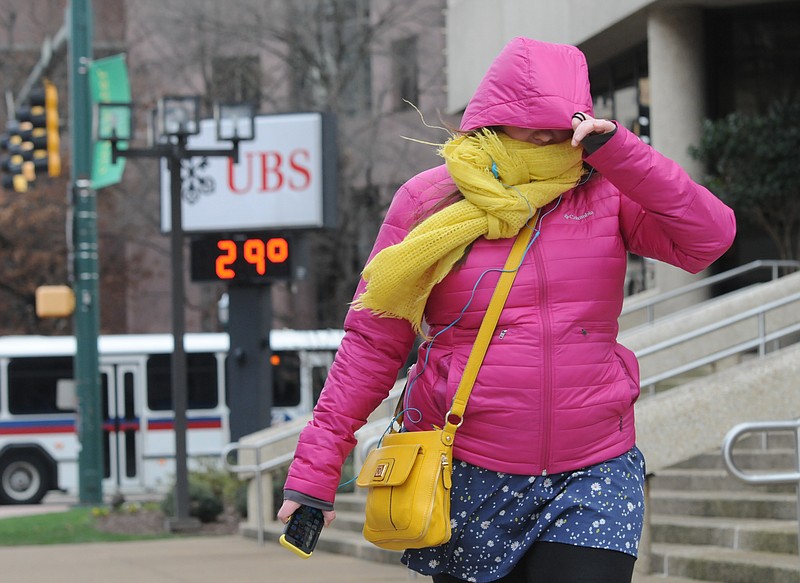 The UBS thermometer reads 29-degrees at the corner of Broad Street and M.L. King Blvd. as Catherine Morrison walks into a cold northwest wind in this Jan. 7, 2015, file photo.