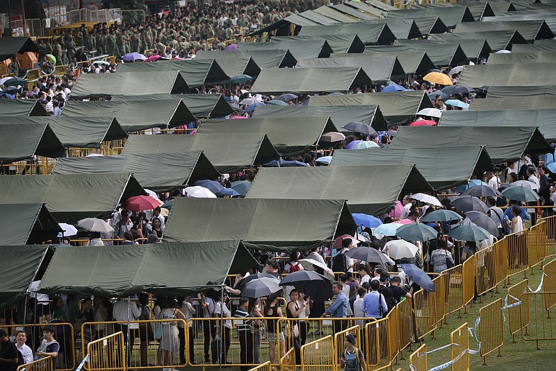 
              Tents are set up to provide shade for members of the public, as they stand in line to pay their respects for the late Lee Kuan Yew at the Parliament House where he will lie in state for four days, Thursday, March 26, 2015, in Singapore. Lee, 91, died Monday at Singapore General Hospital after more than a month of battling severe pneumonia. The government declared a week of mourning for the leader who is credited with transforming the resource-poor island into a wealthy finance and trade hub with low crime and corruption in a region saddled with graft, instability and poverty. (AP Photo/Wong Maye-E)
            