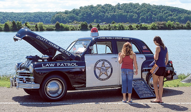 Destiny, left, and Mikayla Lewis look at at a 1949 Plymouth Deluxe four-door sedan the Fourth of July festivities at North Park across from Soddy Lake in Soddy-Daisy.
