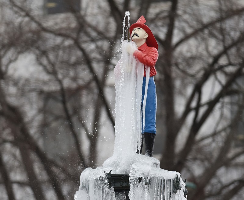 The Firemen's Memorial Fountain on Georgia Avenue begins the day covered in icicles as icy rain falls in early February in Chattanooga.