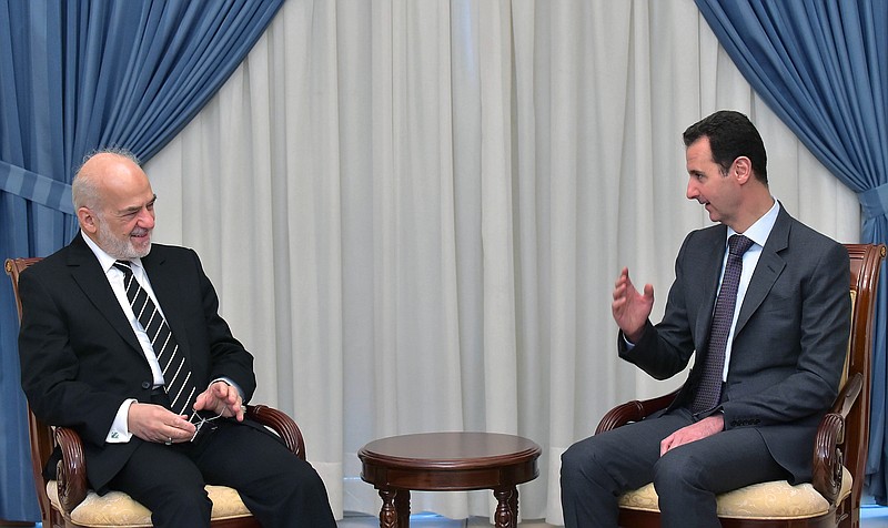 
              In this photo released by the Syrian official news agency SANA, Syrian president Bashar Assad, right, speaks with Iraqi Foreign Minister Ibrahim al-Jaafari, left, in Damascus, Syria, Tuesday, March. 24, 2015. Al-Jaafari said they discussed “Syrian and Iraqi issues, and the common dangers that threaten our security.” (AP Photo/SANA)
            