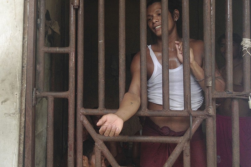 
              In this Saturday, Nov. 22, 2014 image, Kyaw Naing, a slave from Myanmar, talks to a security guard through the bars of a cell at the compound of a fishing company in Benjina, Indonesia. An aid group said Friday, March 27, 2015, that an estimated 4,000 foreign fishermen are stranded on a number of remote islands in eastern Indonesia, including men revealed in an Associated Press investigation to have been enslaved. (AP Photo/Dita Alangkara)
            