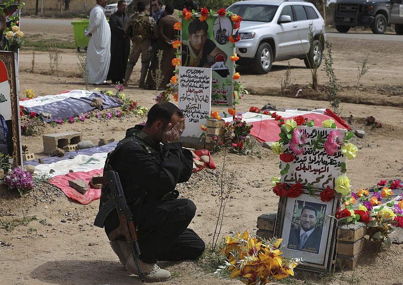 
              In this Wednesday, March 25, 2015, photo, a Sunni fighter from the al-Jabouri tribe weeps in front of the grave of his relative killed in a battle with Islamic State militants, as he visits a cemetery in the town of Duluiyah, 45 miles (75 kilometers) north of Baghdad, Iraq. Sunni tribes that have stood up to the IS group have paid a heavy price, and anger at the Shiite-led government runs deep in the areas of northern and western Iraq that now make up the extremist group's self-styled caliphate. (AP Photo/Karim Kadim)
            