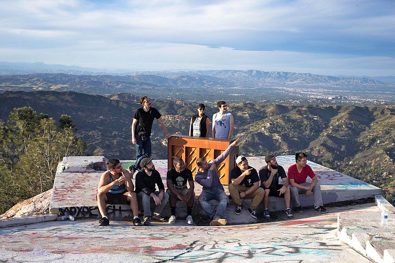 
              In this March, 2015 photo, members of a music video crew pose at Topanga Lookout in the Santa Monica Mountains with an upright piano they hauled up there in Calabasas, Calif. For a couple of days this week, a Southern California hilltop was alive with the sound of mystery.  Hikers venturing to Topanga Lookout found a battered upright piano sitting on a graffiti-scrawled concrete slab with a panoramic view over the mountains between Calabasas and the Pacific Ocean. Turns out, the piano was used for a music video by Seattle-based artist Rachel Wong. The cinematographer, Michael Flotron, says he and four others used a dolly and rope to haul the 350-pound instrument a mile up the trail on Tuesday. After the shoot, it was too dark to get the piano back down. Flotron says people seem happy to leave it there. But if necessary, he’ll haul the piano back down.(AP Photo/Michael Flotron)
            