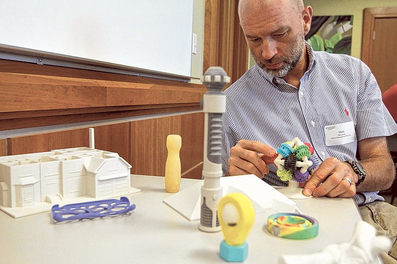 Matt McLellend with Kenco Management Services looks at items made with a 3D printer during a luncheon hosted by the Chattanooga Technology Council at the Business Development Center in Chattanooga.