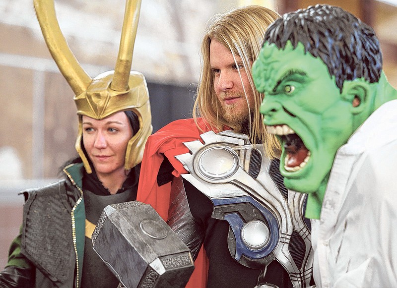 Sarah Heming, dressed as Loki; Ben Rumsey, dressed as Thor; and Terry Sherer, dressed as Hulk, pose for an attendee of Con Nooga to take their photo at the  2014 Chattanooga Convention Center.