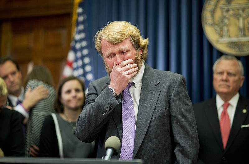 Mike Hopkins, of Covington, Ga., wipes his face as he cries while talking about losing two of his children in the past eight months to complications from their medical conditions at a ceremony where Georgia Gov. Nathan Deal signed an executive order requiring state agencies to start preparations now for the enactment of the state's medical marijuana bill Friday, March 27, 2015, in Atlanta.