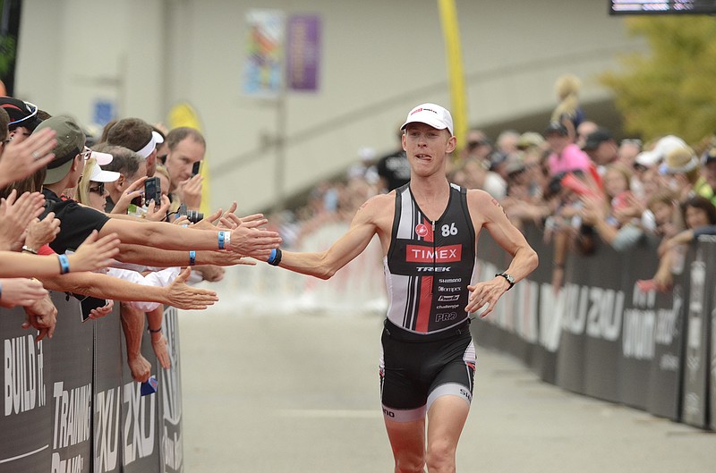 Daniel Bretscher of Mount Vernon, Iowa, receives congratulations from spectators as he nears the finish line headed to a second-place finish in Ironman Chattanooga.