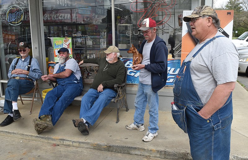 James "Bo" Lewis, Mike Short and William Anderson, from left, sit on a bench in front of Sam's Family Grocery on Mach 26, 2015, in Lyerly, Ga., as they talk with Joe Martin and former Mayor Daniel Wyatt, right. Martin is holding his dog, Gizmo.