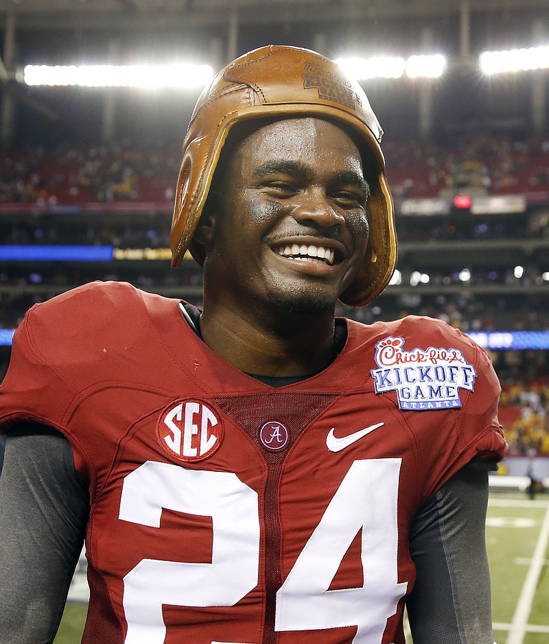 Alabama defensive back Geno Smith (24) wears a leather helmet that is part of the Chick-fil-A kickoff Game trophy in this 2014 file photo.