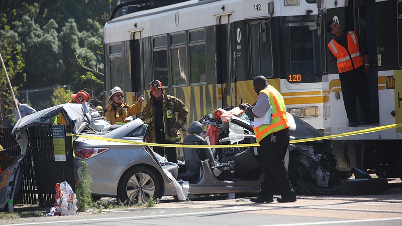 Emergency personnel work at the site of a collision between and Expo Line commuter train and a vehicle near downtown Los Angeles on Saturday, March 28, 2015. Firefighters say nearly two dozen people suffered injuries, mostly minor. (AP Photo/Los Angeles Times, Irfan Khan) 