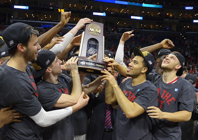 Wisconsin players hold the trophy after beating Arizona 85-78 in a college basketball regional final in the NCAA Tournament to advance to the Final Four on Saturday, March 28, 2015, in Los Angeles. 