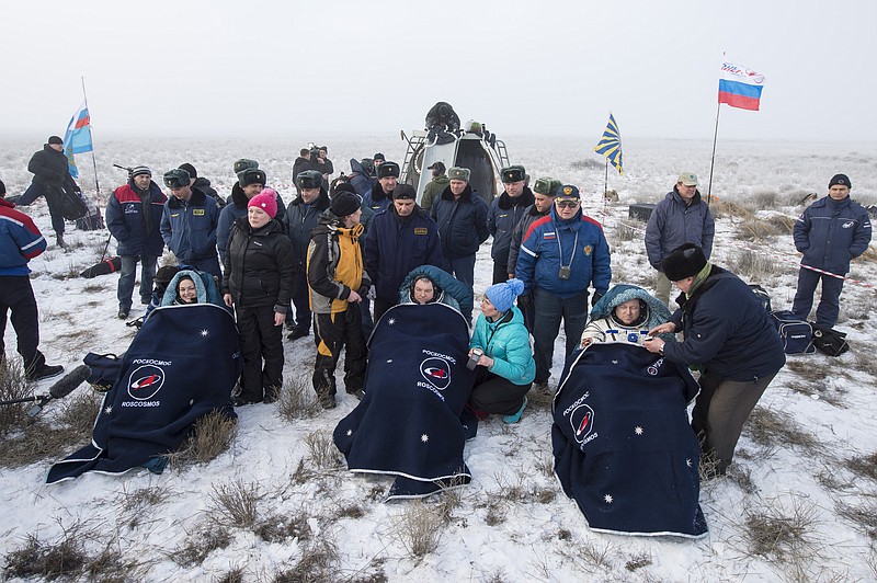 Russian Cosmonauts Elena Serova, left, Alexander Samokutyaev of Roscosmos, center, and NASA Astronaut Barry Wilmore of NASA sit in chairs outside the Soyuz TMA-14M spacecraft just minutes after they landed in a remote area near the town of Zhezkazgan, Kazakhstan on March 12, 2015. 