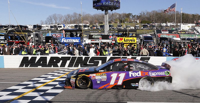 Denny Hamlin does a burnout after winning the NASCAR Sprint Cup Series auto race at Martinsville Speedway in Martinsville, Va., Sunday, March 29, 2015. 