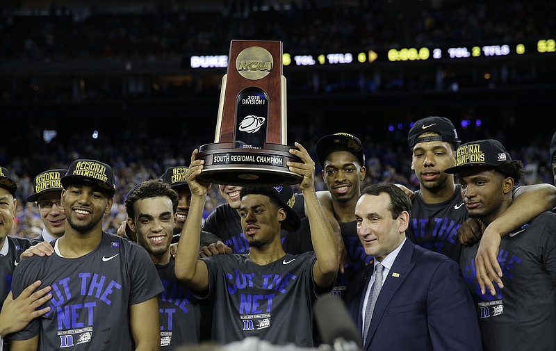 Duke players and head coach Mike Krzyzewski hold up the championship trophy after a college basketball regional final game against Gonzaga in the NCAA Tournament on March 29, 2015, in Houston. Duke won 66-52 to advance to the Final Four.