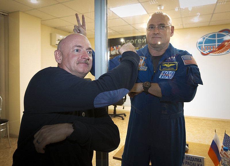 
              FILE - In this March 26, 2015, file photo, U.S. astronaut Scott Kelly, right, crew member of the mission to the International Space Station, ISS, poses through a safety glass with his brother, Mark Kelly, also an astronaut after a news conference in Russian leased Baikonur cosmodrome, Kazakhstan. NASA Administrator Charles Bolden told Scott Kelly on Monday, March 30, 2015, that he almost had a heart attack when his identical twin showed up launch morning without his usual mustache late last week. (AP Photo/Dmitry Lovetsky, File)
            