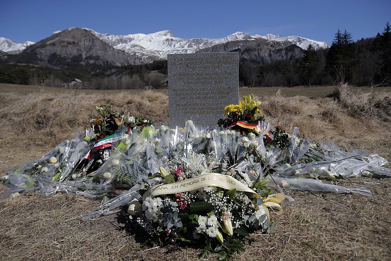 
              A stele and flowers laid in memory of the victims are placed in the area where the Germanwings jetliner crashed in the French Alps, in Le Vernet, France, Friday, March 27, 2015. The crash of Germanwings Flight 9525 into an Alpine mountain, which killed all 150 people aboard, has raised questions about the mental state of the co-pilot. Authorities believe the 27-year-old German deliberately sought to destroy the Airbus A320 as it flew Tuesday from Barcelona to Duesseldorf. (AP Photo/Christophe Ena)
            