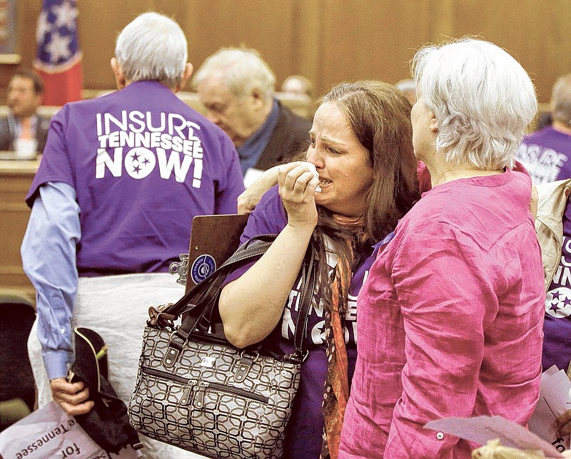 Tracy Foster, center, of Clinton, Tenn., cries after Gov. Bill Haslam's Insure Tennessee proposal was voted down by the Senate Commerce Committee on Tuesday in Nashville. Foster is a cancer patient who has no insurance. The proposal to extend health coverage to about 280,000 low-income Tennesseans was defeated 6-2.