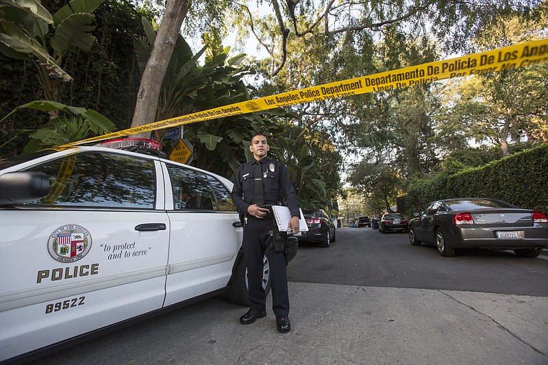 
              An officer stands outside a home in the Hollywood Hills area of Los Angeles, Tuesday, March 31, 2015. Police say a man was found dead at the home of Andrew Getty, heir to Getty oil fortune. (AP Photo/Ringo H.W. Chiu)
            