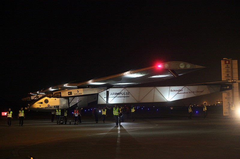 
              Ground crew members move a solar powered plane into a hangar after it landed at Chongqing Jiangbei International Airport in southwest China's Chongqing Municipality, Tuesday, March 31, 2015. The Solar Impulse 2 landed in Chongqing early Tuesday after a 20-hour, 1,375-kilometer (854 mile) flight from Mandalay, Myanmar, on the fifth leg of the plane's attempt to circumnavigate the globe. (AP Photo) CHINA OUT
            