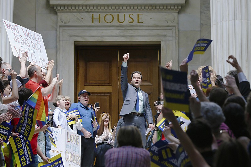In this Monday, March 30, 2015, file photo,m Rep. Warwick Sabin, D-Little Rock, center, cheers with protesters outside of the House chamber at the Arkansas state Capitol in Little Rock, Ark.