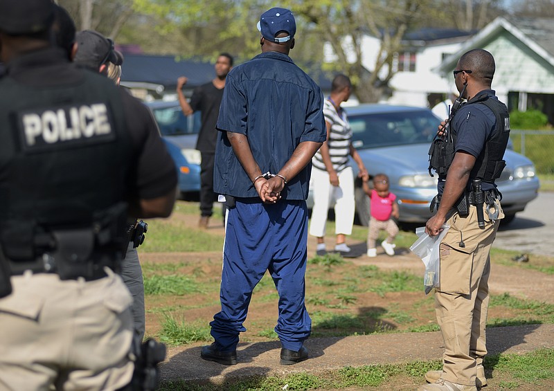 Jerry Moore, center, was charged with selling crack cocaine to an undercover officer on Doris Street on Wednesday, Apr. 1, 2015, in Chattanooga. Several Chattanooga Police Department officers worked their way through the city on Wednesday in an operation designed to arrest street drug dealers