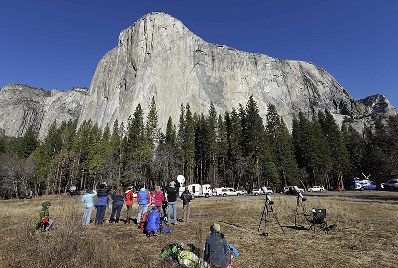
              FILE - In this Jan. 14, 2015, file photo, spectators gaze at El Capitan for a glimpse of climbers Tommy Caldwell and Kevin Jorgeson, as seen from the valley floor in Yosemite National Park, Calif. Be prepared to pay a bit more if you’re going to visit some of the national parks and recreation areas this summer. After a six-year moratorium, the federal government has begun increasing the price of admission at some of its public lands and the fees charged for camping, boating, cave tours and other activities. The National Park Service says the money raised is just a fraction of the $11.5 billion needed to fix roads, trails and park buildings. (AP Photo/Ben Margot, File)
            