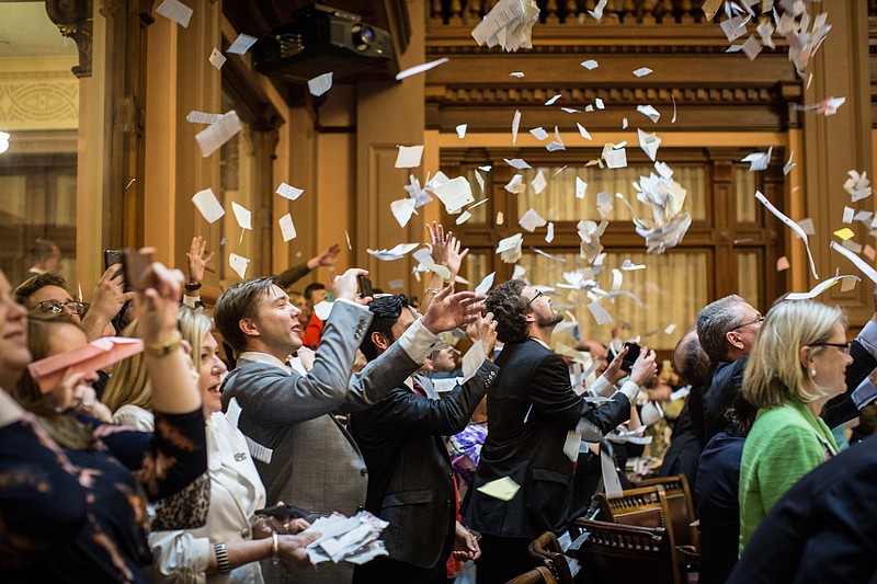 
              House members throw up paper at the conclusion of the legislative session in the House Chamber, Friday, April 3, 2015, in Atlanta.  By law, Georgia's General Assembly meets for 40 working days each year. Any bills not approved by each chamber by midnight are dead for the year.   (AP Photo/Branden Camp)
            