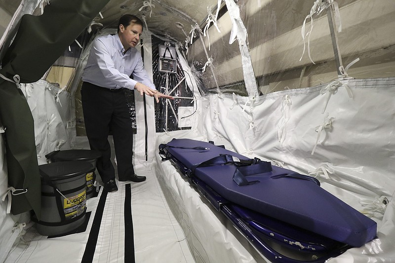 Clay Wardlaw, president/COO of SafetyPlus, stands inside an airtight compartment in Phoenix Air Group's Gulfstream III jet used to transport Ebola patients to treatment centers.