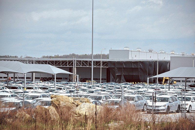 As newly assembled vehicles await delivery at Volkswagen Chattanooga, a large black curtain protects an expansion of the automaker's body shop.