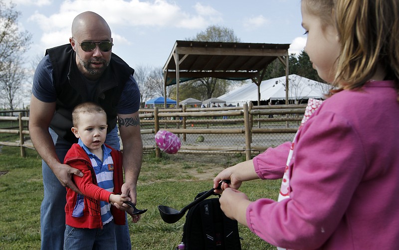 Ava Sammons, right, tosses an egg to her brother Eli and father Tex at the Chattanooga Zoo's annual Hug A Bunny Day fundraiser Saturday, April 4, 2015, in Chattanooga. The event included a chance for kids to pet live rabbits, collect eggs for participating in games, and get a photo with the Easter Bunny.