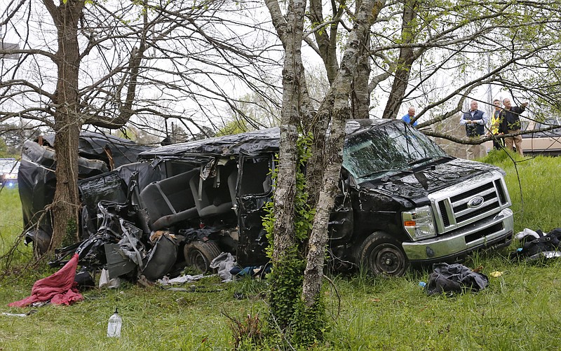 Investigators work at the scene where three people died early Monday, April 6, 2015, when a van carrying members of two heavy metal bands crashed near the town of Commerce, Ga., about 65 miles northeast of Atlanta, according to authorities. 