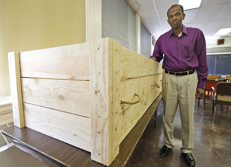 
              Rev. Alfred L. Jones III poses with a period style pine box coffin that will be used to represent former slave Hannah Reynolds, who was the lone civilian death at Appomattox at the end of the war, at the Carver-Price Legacy Museum in Appomattox, Va., Wednesday, April 1, 2015. Jones will deliver the eulogy for Reynolds whose death will be remembered during the 150th anniversary of the Civil War's end. (AP Photo/Steve Helber)
            