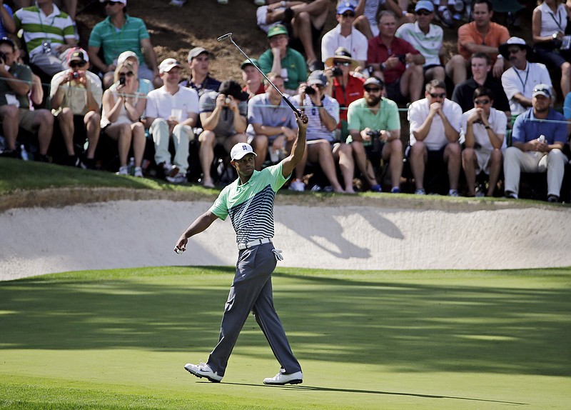 Tiger Woods waves his putter during the Par 3 contest at the Masters golf tournament Wednesday, April 8, 2015, in Augusta, Ga.