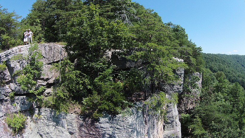 At left atop Castle Rock, Jean Cheveallier, project manager for The Land Trust of Tennessee, remotely flies a camera-equipped drone off the cliff of the turret-shaped sandstone bluff. Zachary Lesch-Huie, at right, is from The Access Fund.