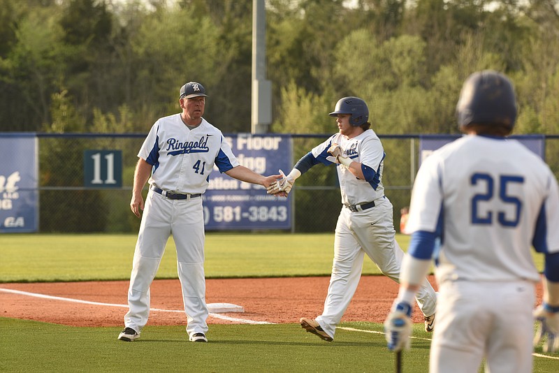 Ringgold catcher Ethan Dalton, right, gets a congratulating hand from Tigers coach Brent Tucker following an RBI double for the games first run in the bottom of the fourth inning against the visiting Calhoun Yellowjackets on Thursday, April 9, 2015. The Tigers won 4-3.