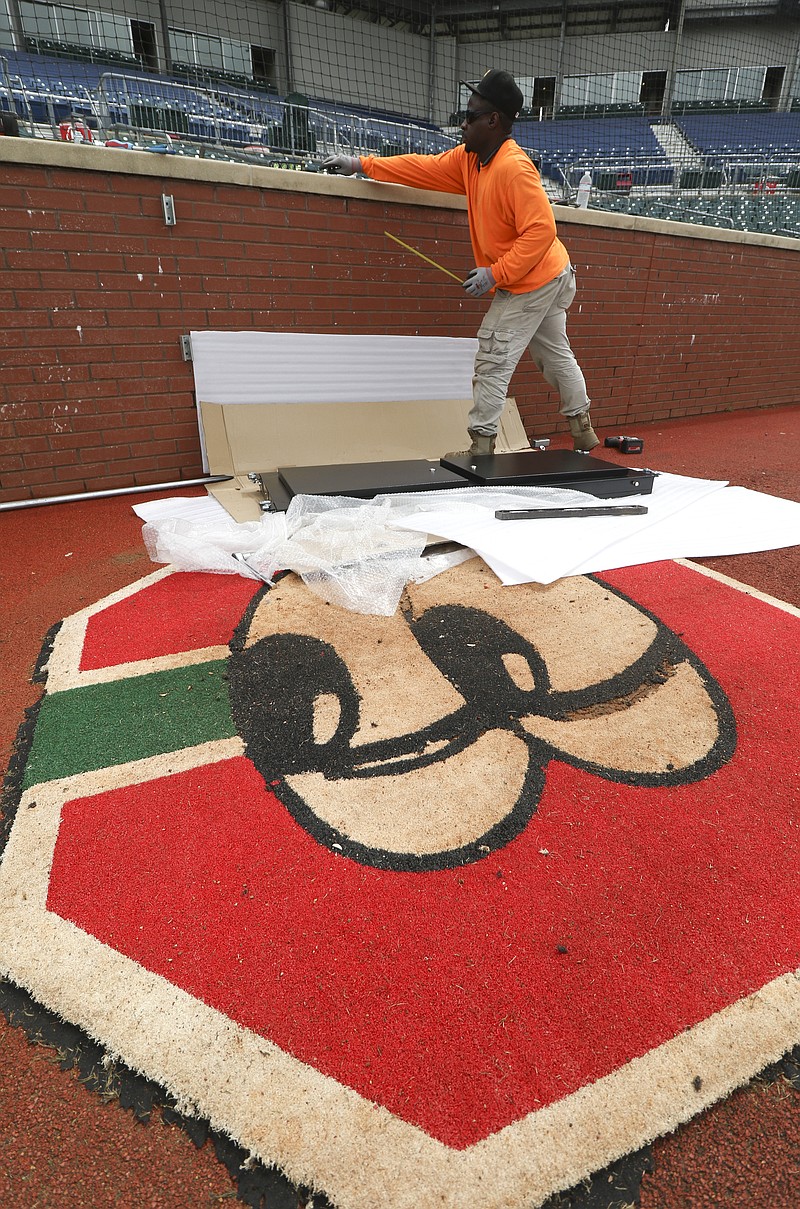 Marcus Sprawls from Atlanta, Ga., installs a pitcher clock in preparation for the Chattanooga Lookouts 2015 baseball season. 