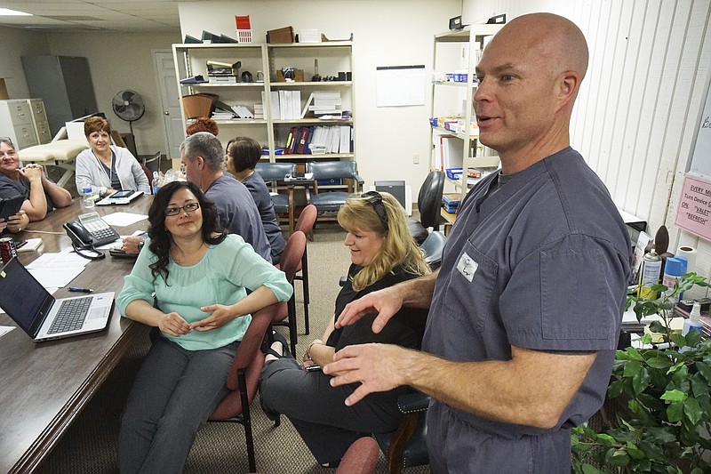 Brent Ashley a Doctorate Physical Therapist at Home Care Solutions in Ooltewah, Tenn., right, speaks during a case conference meeting on April 8, 2015. Ashley won "Therapist of the Year" through the LHC Group. 