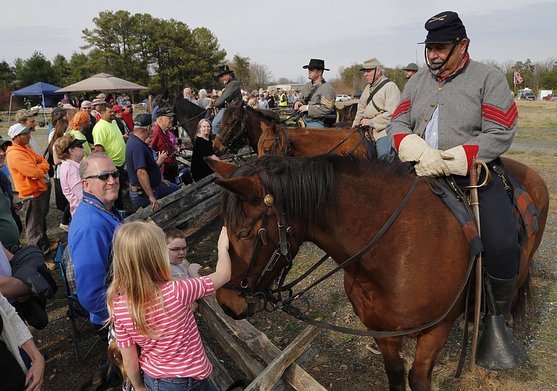 
              Civil War re-enactor Steve Riggs, of Charleston S.C., with the 2nd Virginia Cavalry, lets visitors pet his horse, Jackson, before a re-enactment of the Battle of Appomattox Station, Wednesday, April 8, 2015, as part of the 150th anniversary of the surrender of the Army of Northern Virginia to Union forces at Appomattox Court House, in Appomattox, Va. (AP Photo/Steve Helber)
            