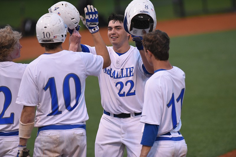 McCallie first baseman Ethan Cady (22) gets a warm welcome at the plate from teammates William Korn (2), Quinn Smith (10) and Tyler Payne (11) after a 3-run dinger in their game against Bradley Central on April 7, 2015. 