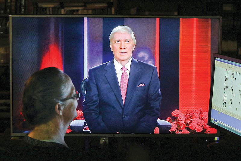 Esther Wilson, floor director for the John Ankerberg Show, left, watches a monitor displaying John Ankerberg as he sits in his Chattanooga studio on April 7, 2015, where he films a Christian evangelist TV show attempting to prove the existence of god. 