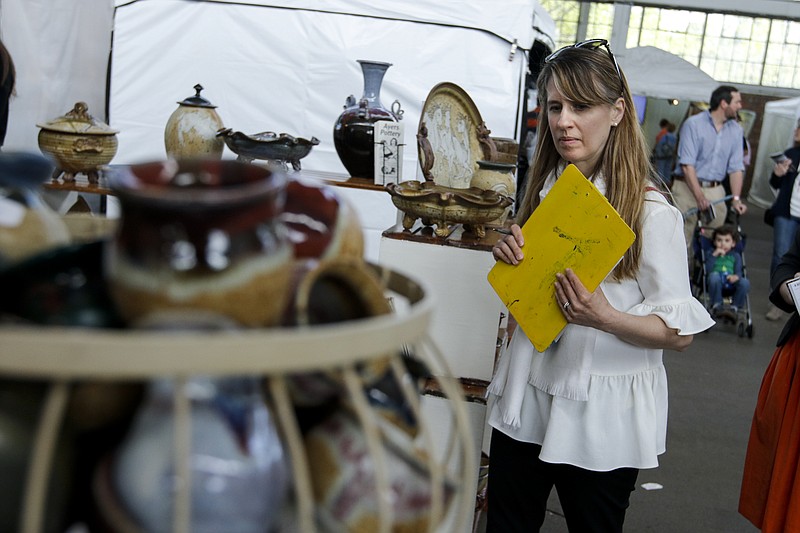 Juror Katie Delmez judges ceramics on display at an artist's tent Saturday, April 11, 2015, at the 4 Bridges Art Festival at the First Tennessee Pavilion in Chattanooga. The annual show of fine arts and crafts drew 500 artists from across the country.