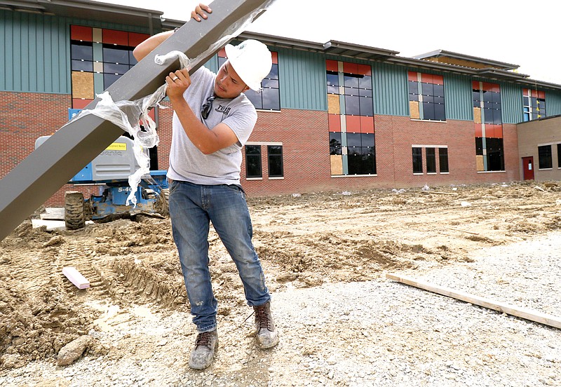 Christian Santos unloads new materials in front of the school as construction continues on East Brainerd Elementary School on April 9, 2015. 